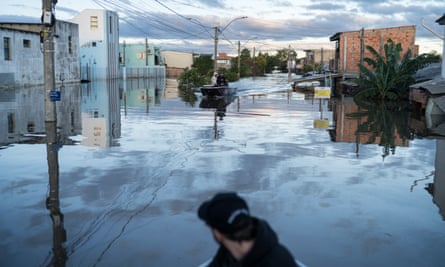 People in boats in flooded streets.