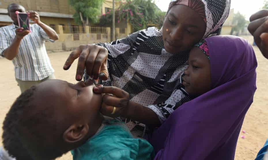 Health workers immunise a child in Nigeria