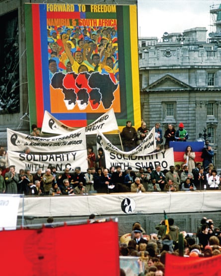 Protesters at a march against apartheid in Trafalgar Square hold banners.
