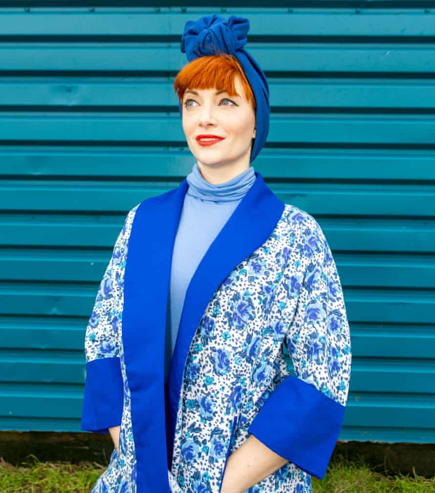 Amber Butchart wearing a blue patterned, kimono-style jacket over a blue polo neck, with a royal blue turban