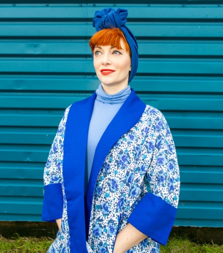 Amber Butchart wearing a blue patterned, kimono-style jacket over a blue polo neck, with a royal blue turban