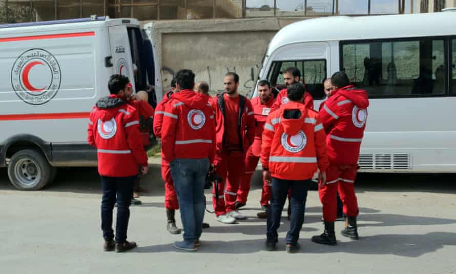 Volunteers from the Syrian Arab Red Crescent stand near ambulances on Monday.