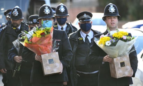 Police officers with flowers arrive at Croydon Custody Centre in south London where a police officer was shot.