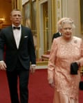 Actor Daniel Craig playing James Bond escorting Queen Elizabeth II through the corridors of Buckingham Palace
