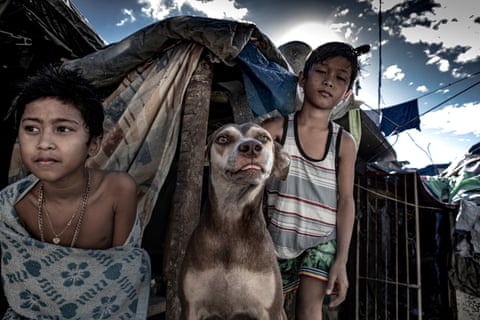 Two young inhabitants of Pasay cemetery with their dog.