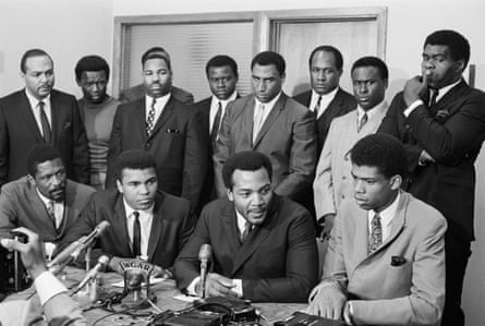 Une conférence de presse lors d'une réunion de stars du sport en 1967 pour examiner le cas de Cassius Clay (plus tard Muhammad Ali) pour avoir rejeté le projet du Vietnam. Jim Brown est assis au premier rang, deuxième à partir de la droite, avec, à partir de la gauche, Bill Russell, Cassius Clay et Lew Alcindor.