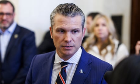 a man in a suit speaks to a person holding a microphone