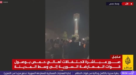 People are gathered in the centre of Homs celebrating its capture by HTS.