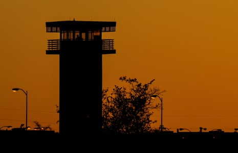 a prison complex is silhouetted during sunset