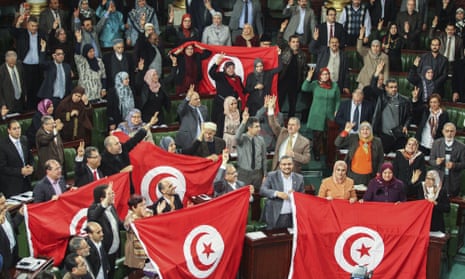Members of the Tunisian national constituent assembly celebrate the adoption of the new constitution in 2014.