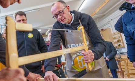 Friedrich Merz using a saw in a workshop