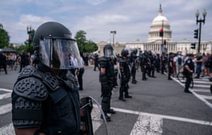 Capitol Police dressed in riot gear look on as activists react to the supreme court’s ruling in front of the supreme court.