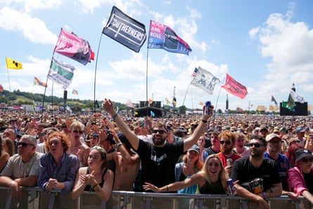 Crowds of people at a stage, many holding flags