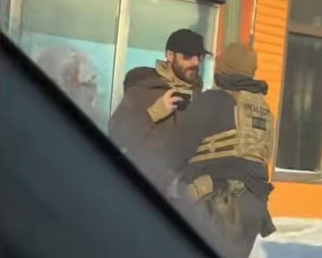 A still image of Alex Pretti recording video on his phone as he was shoved back by a federal agent minutes before being shot and killed.