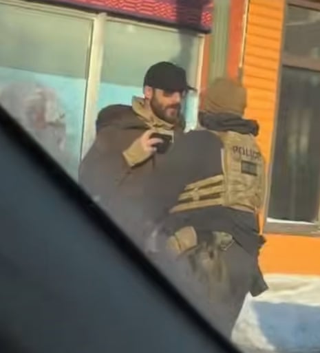 A still image of Alex Pretti recording video on his phone as he was shoved back by a federal agent minutes before being fatally shot on Saturday in Minneapolis.