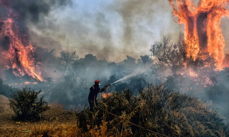 Firefighters douse flames of a wildfire near the seaside town of Agioi Theodoroi, about 70km west of Athens