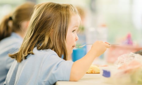 Young girl eating a school dinner
