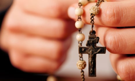 A woman holding a rosary bead