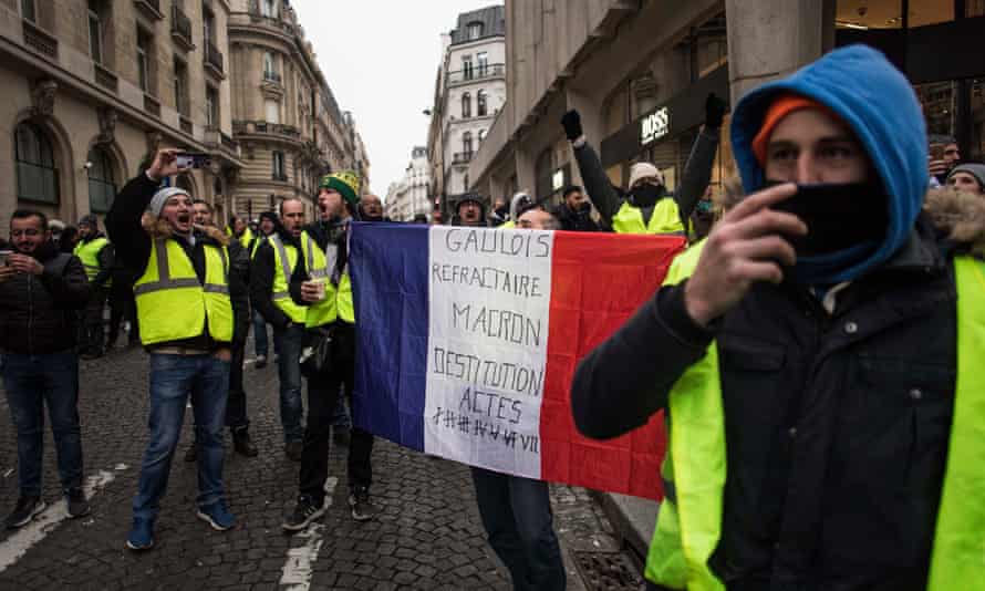 A man holds a french flag during a gilets jaunes protest in Paris on Saturday