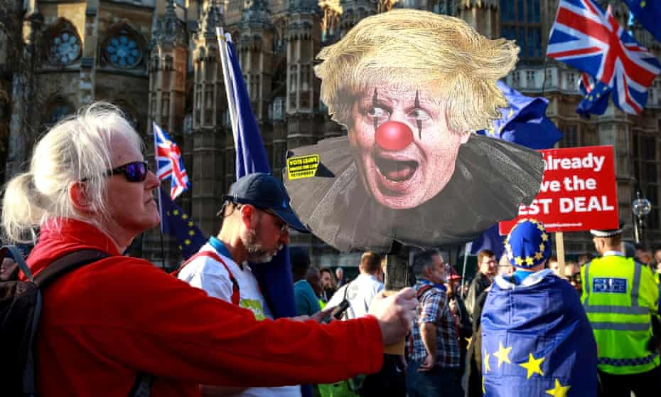 Anti-Brexit protester carrying poster of Boris Johnson in clown makeup