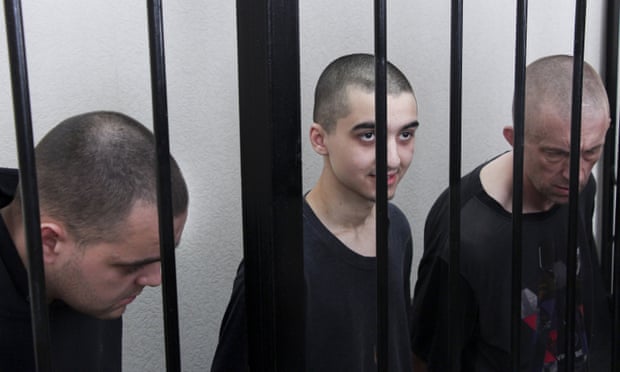 British citizens Aiden Aslin (left) and Shaun Pinner (right), with Moroccan Brahim Saadoun  in a courtroom in Donetsk