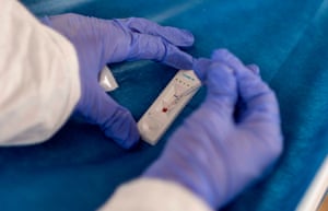 Gloved hands testing a blood sample