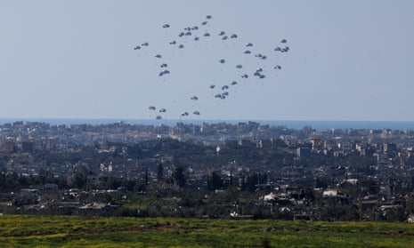 Packages fall towards northern Gaza, after being dropped from a military aircraft.