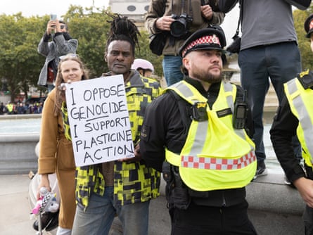 A man holding up a placard saying: ‘I oppose genocide, I support plasticine action’ A man holding up a placard saying: ‘I oppose genocide, I support plasticine action’