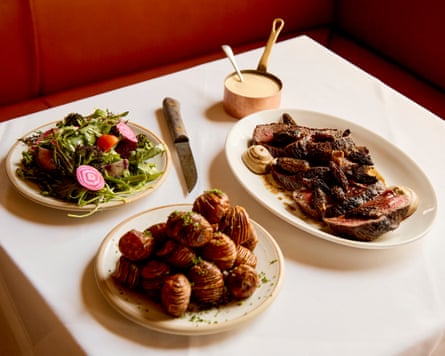 plated beef fillet with morels, a pot of sauce and a plate of hasselback potatoes
