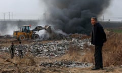 A man looks on as a bulldozer piles up garbage to burn on the outskirts of Baoding, Hebei province, China. In recent weeks, Chinese chat groups and WeChat feeds have been buzzing with discussion about if China is in a “garbage time of history”.