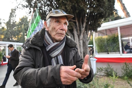 he is holding out his hands and gesticulating.