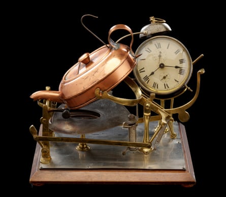 Automatic tea-making machine, comprising wooden base which holds the alarm clock, kettle tilter and methylated spirit stove, with flat oval-shaped copper kettle, patented by Frank Clarke of Birmingham, in 1902 and made by the Automatic Water Boiler Co, Birmingham, England, 1902-1910.