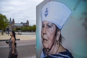 Amsterdam, Netherlands: A woman passes by an outdoor photography exhibition that celebrates diversity in Museum Square as the city prepares for gay pride Canal Parade