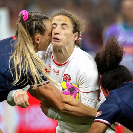 Abby Dow of England clashes heads with McKenzie Hawkins of the USA as she and Bulou Mataitoga make a tackle.