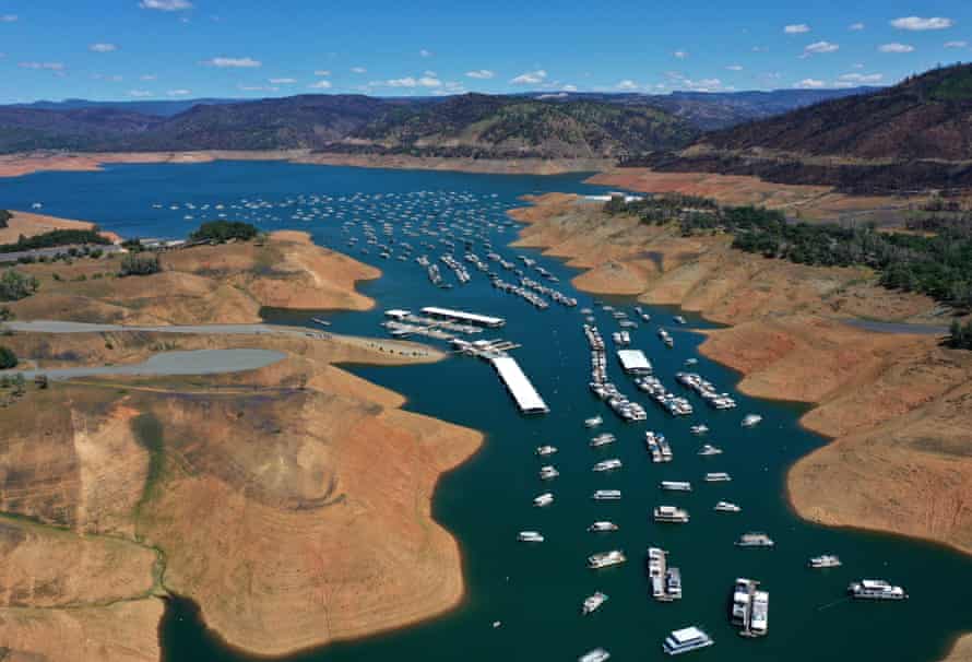 Houseboats in Lake Oroville are dwarfed by the exposed banks.