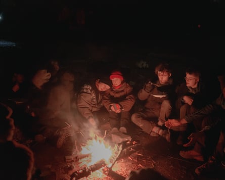 Activists warm themselves by a bonfire