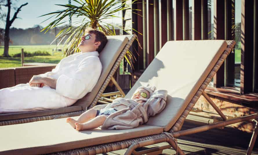 Seamus O’Reilly lying on one sun lounger and his baby son on another, both with pieces of cucumber over their eyes