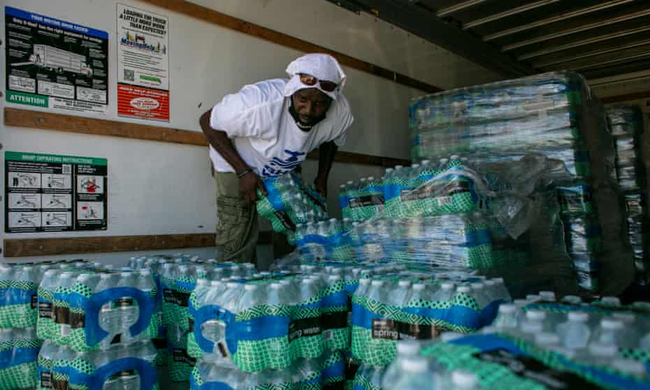 A volunteer hands out water to residents in Benton Harbor, 10 September 2021.