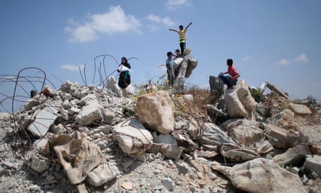 Palestinian children on 7 July 2015 in the village of Khuzaa, east of Khan Yunis in the Gaza Strip, play in the rubble of houses destroyed a year earlier.