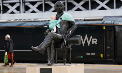 Statue of seated Isambard Kingdom Brunel with a model baby wrapped around in a sling