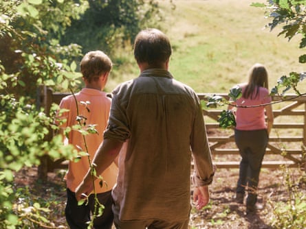 John and family viewed from behind walking towards a gate into a field.