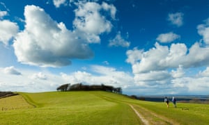 Hikers on South Downs Way walking towards Chanctonbury Ring, West Sussex.