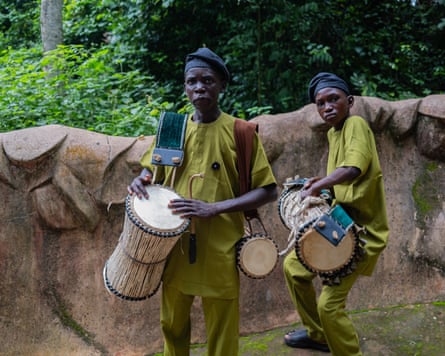 An African man and a boy wearing green tunics and trousers