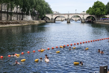 People swim near the Pont Marie in Paris