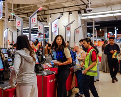 Customers use a self-serve checkout counter at Coles supermarket