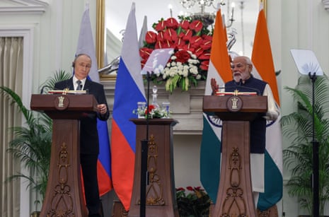 Putin and Modi stand at plinths with their country's flags behind them.