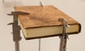 A very old-looking book suspended on callipers