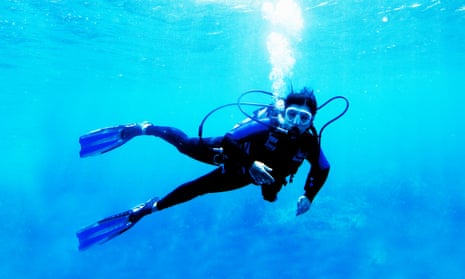 Woman scuba diver in blue ocean.