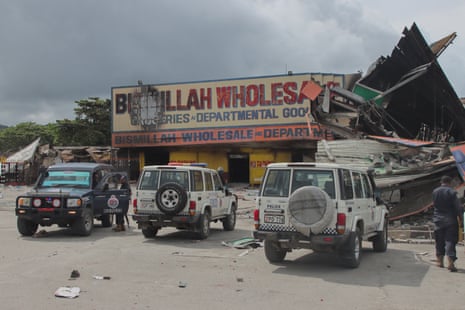 Police work at the site of a damaged building in Port Moresby on 12 January 2024. Troops patrolled the streets of Papua New Guinea’s capital on January 12, under a state of emergency following riots that killed 16 across the country’s two largest cities. (Photo by DARRELL TOLL / AFP) (Photo by DARRELL TOLL/AFP via Getty Images)