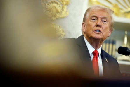 Donald Trump answers questions from reporters during an event in the Oval Office of the White House.